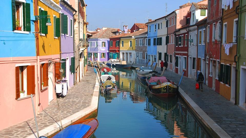 Île de Murano, à proximité de Venise. Le paysage y est ensoleillé et les maisons de toutes les couleurs. Le canal est assez large pour laisser passer de petits barques mais sans plus.