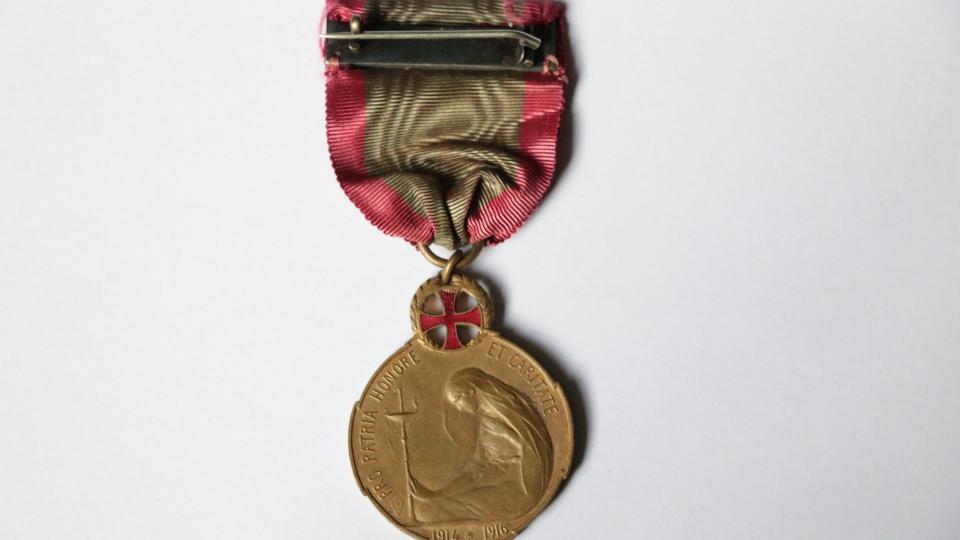 Revers de la médaille représentant une figure féminine parée du voile de la nurse tenant une lampe à l’huile — référence à Florence Nightingale, la dame à la lampe, pionnière anglaise des soins infirmiers. La médaille est ornée d'une croix rouge pour souligner le fait qu'elle soit dédiée au personnel médical